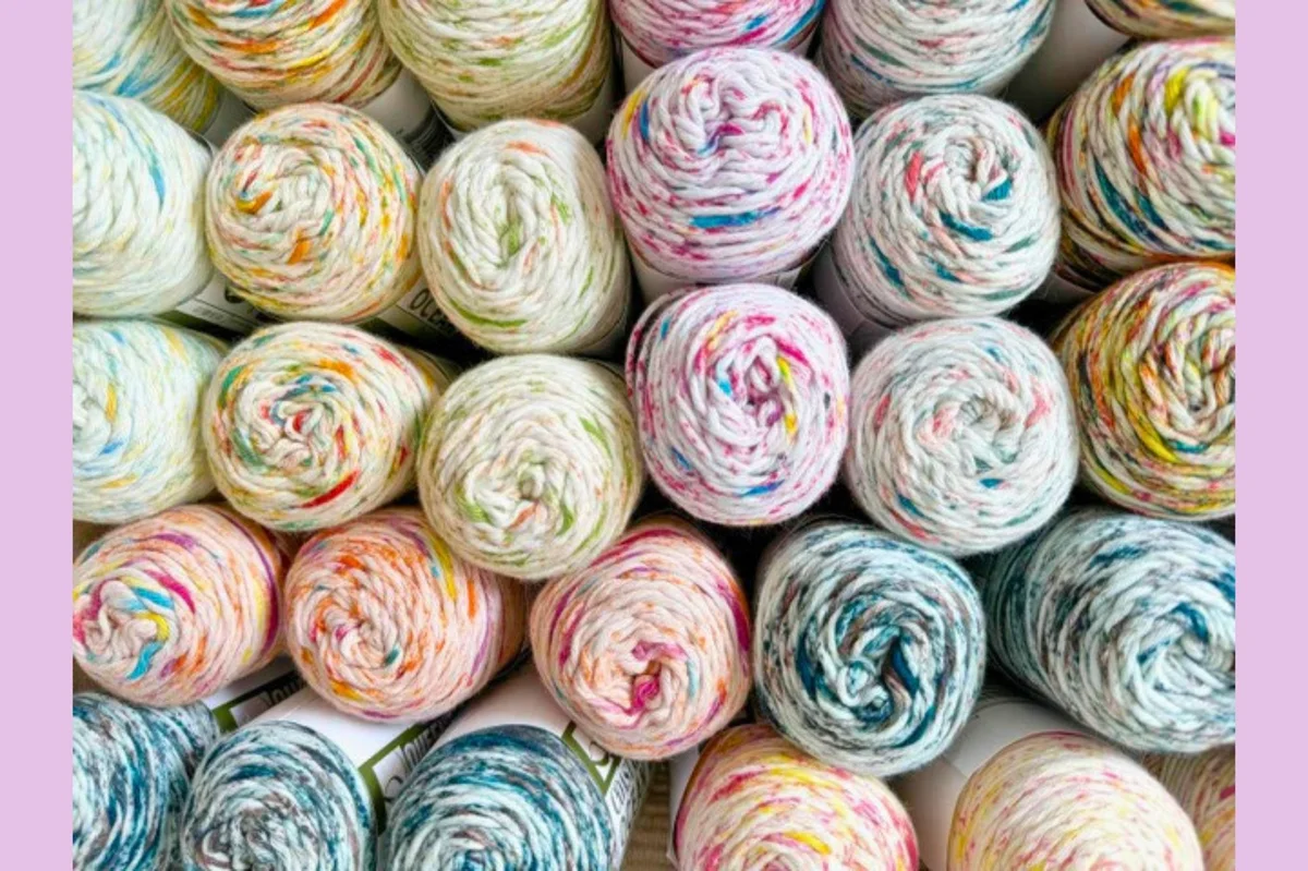 Colorful Queensland Collection yarn skeins arranged in a line