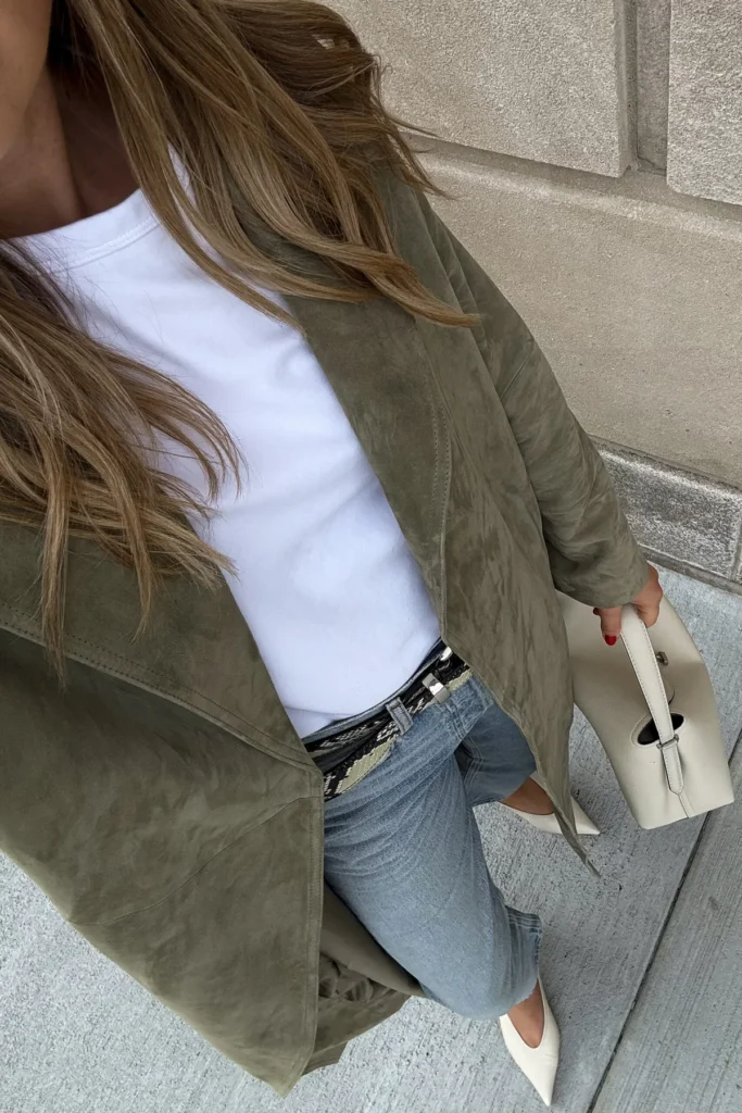 Woman in olive green suede trench coat styled over jeans and white tee