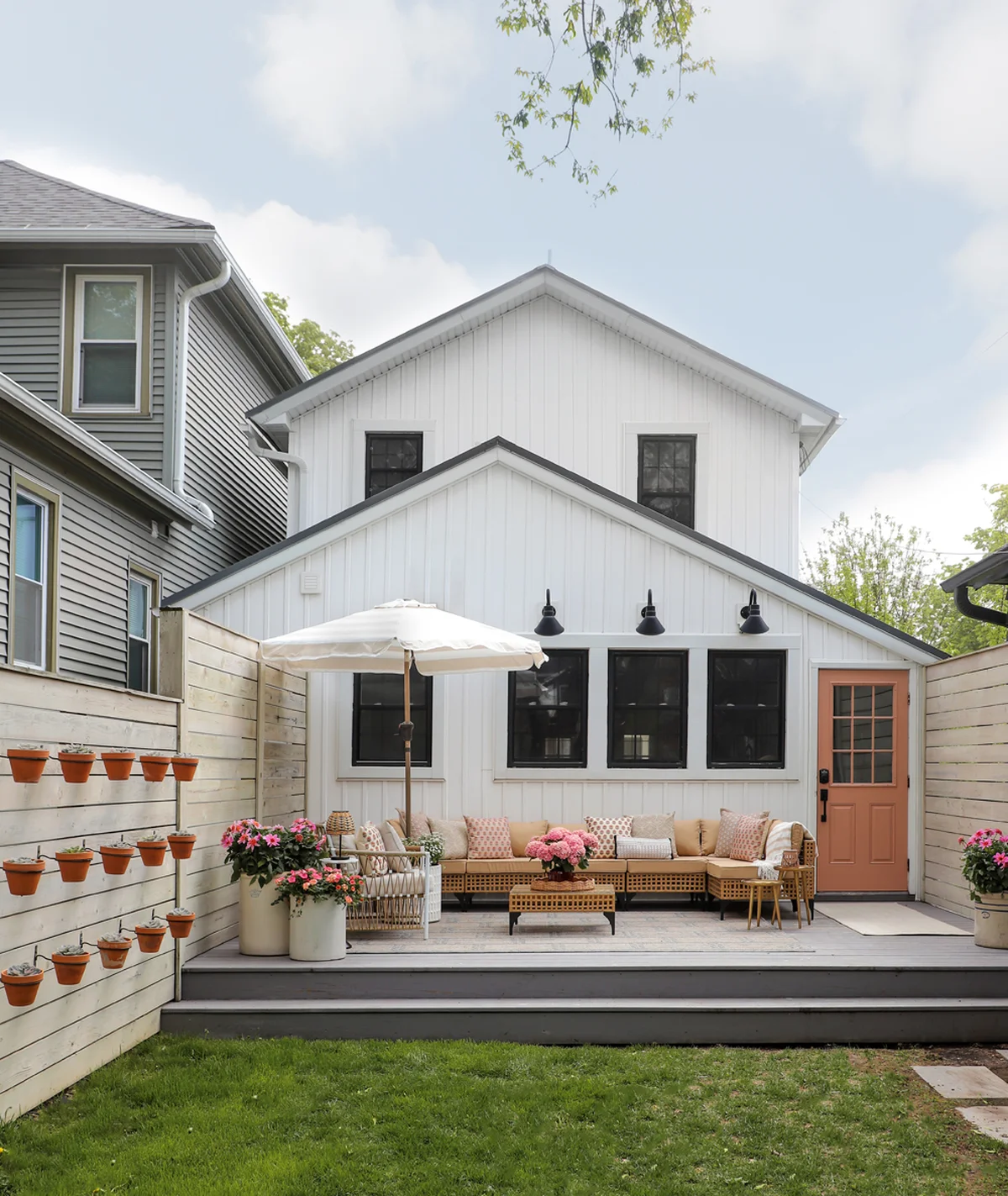 Stylish backyard patio with neutral furniture and peach door