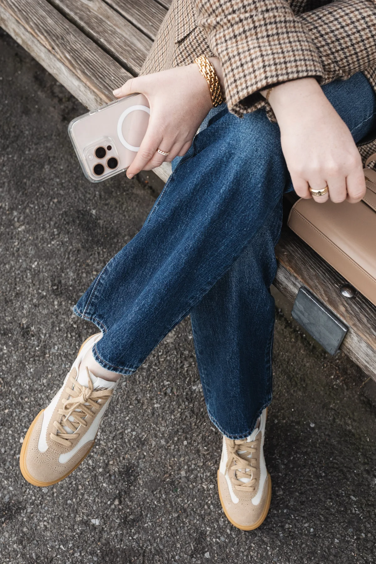 Cream and tan suede sneakers styled with wide-leg jeans on a bench