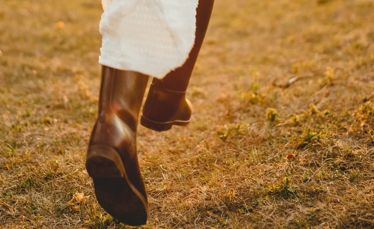 Chunky boots styled with a white skirt in golden autumn light