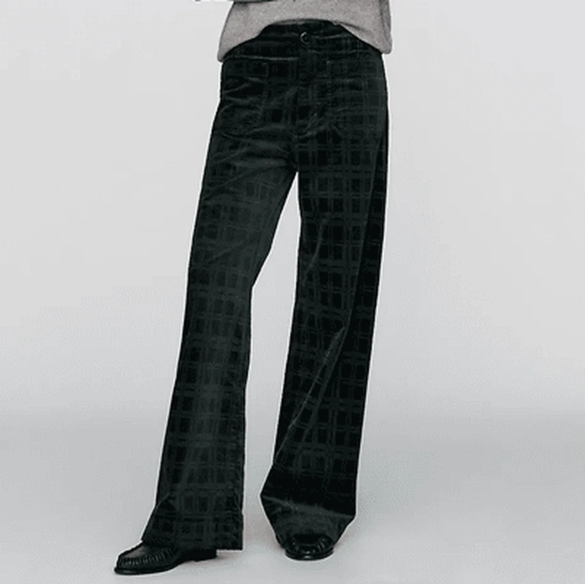 Dark straight-leg corduroy pants in a minimalist studio product shot.